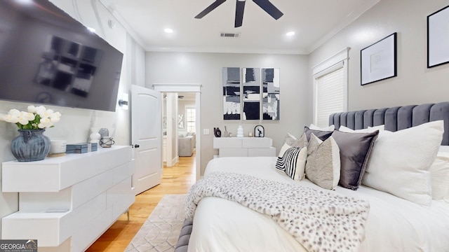 bedroom with visible vents, crown molding, ceiling fan, recessed lighting, and light wood-style flooring