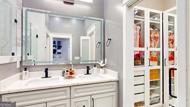 full bath with a sink, an enclosed shower, and double vanity