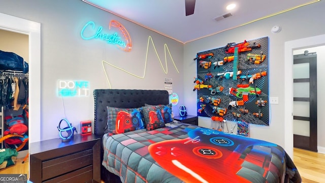 bedroom featuring visible vents, wood finished floors, and a ceiling fan