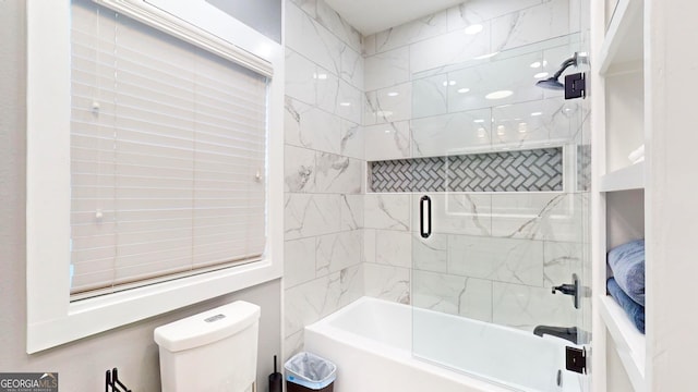 full bathroom featuring toilet and shower / bath combination with glass door