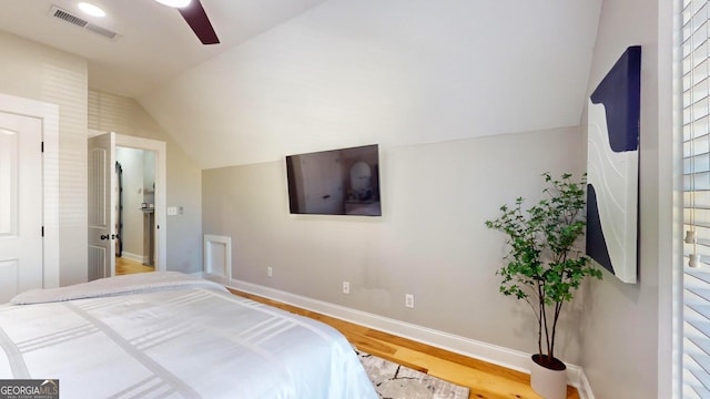 bedroom featuring light wood-style floors, lofted ceiling, baseboards, and visible vents