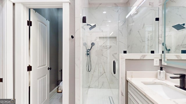 bathroom featuring a marble finish shower, marble finish floor, and vanity