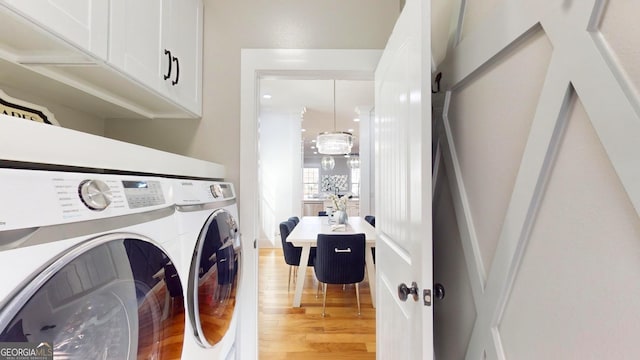 laundry area with cabinet space, independent washer and dryer, and light wood-style flooring