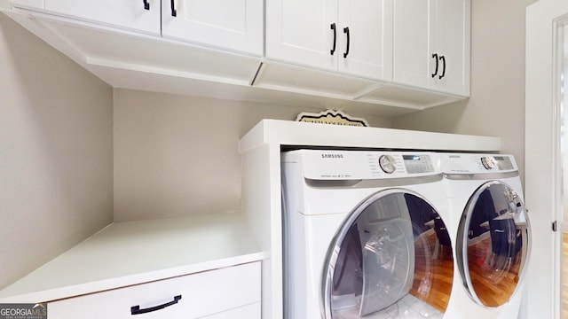 clothes washing area with cabinet space and washing machine and clothes dryer