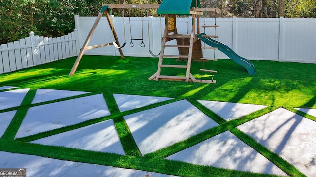 view of playground featuring a fenced backyard and a lawn