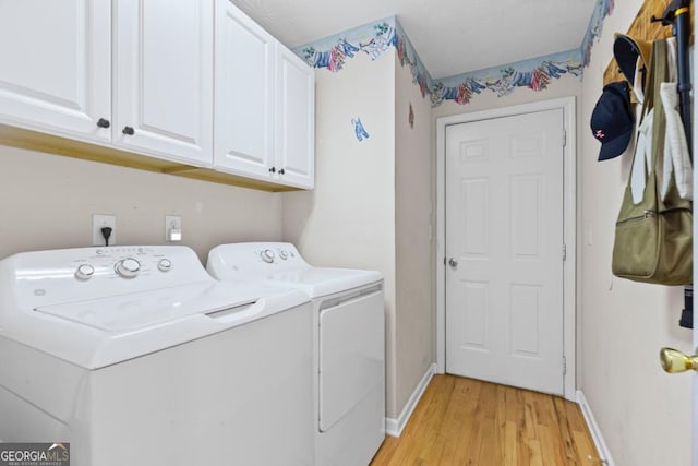 laundry area with washer and dryer, cabinet space, baseboards, and light wood finished floors