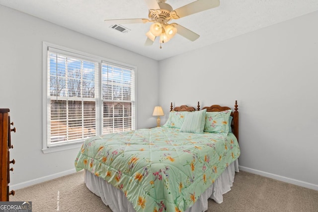 carpeted bedroom featuring visible vents, baseboards, and ceiling fan