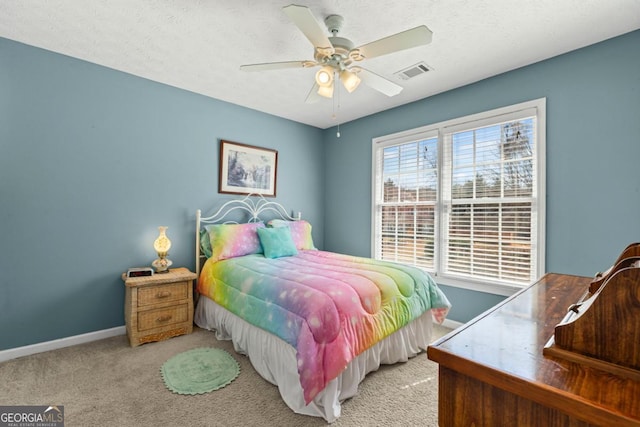 bedroom with visible vents, a textured ceiling, carpet flooring, baseboards, and ceiling fan