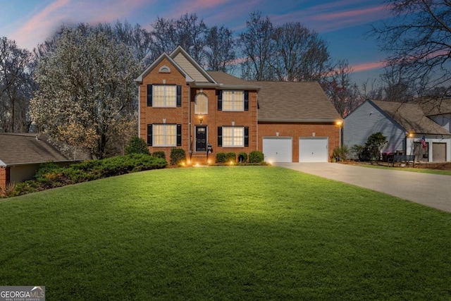 colonial house with a yard, brick siding, concrete driveway, and an attached garage