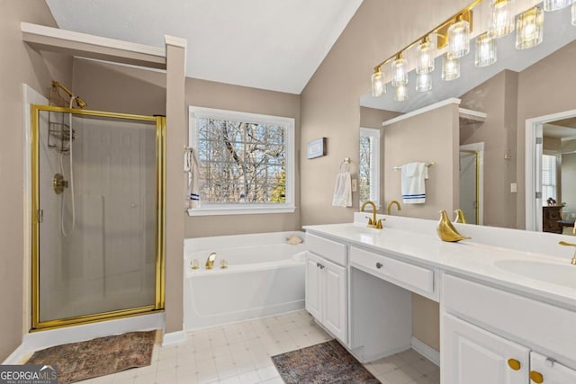 bathroom featuring a shower stall, a garden tub, double vanity, vaulted ceiling, and a sink