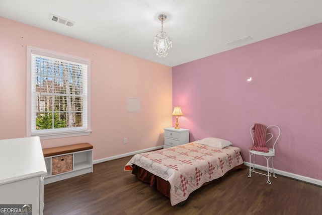 bedroom with visible vents, baseboards, and wood finished floors