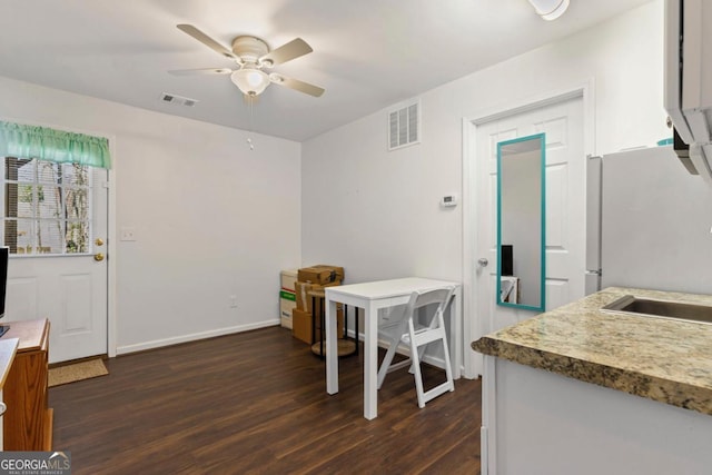 dining room with dark wood-style floors, visible vents, and ceiling fan