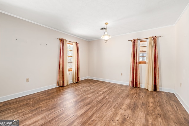 unfurnished room featuring ornamental molding, baseboards, and wood finished floors