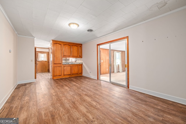 unfurnished living room featuring light wood-style flooring, baseboards, and ornamental molding