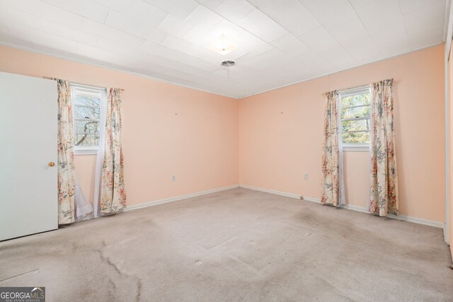 carpeted empty room featuring baseboards