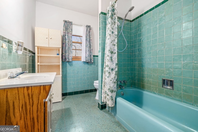 full bath with toilet, tile walls, shower / bath combination with curtain, speckled floor, and vanity