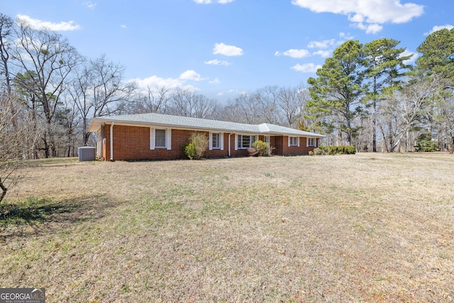 ranch-style home with brick siding, central AC, and a front yard