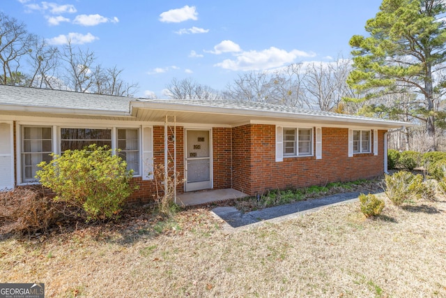 single story home featuring brick siding