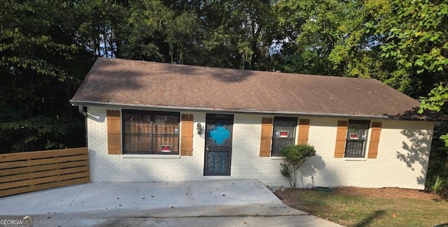 single story home featuring brick siding and fence