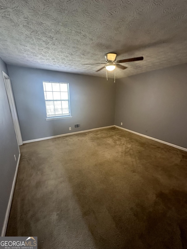 carpeted empty room featuring visible vents, baseboards, a textured ceiling, and ceiling fan