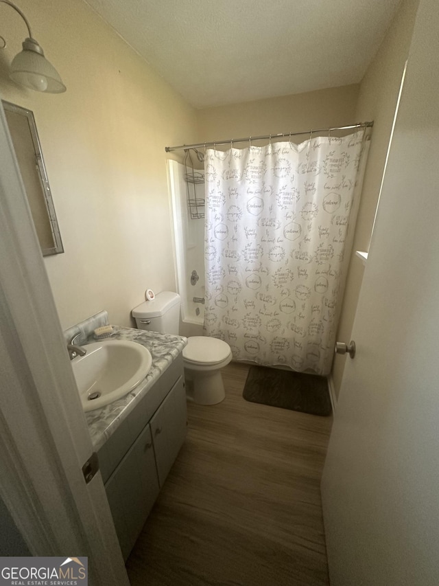 full bathroom featuring vanity, toilet, wood finished floors, and shower / bath combo