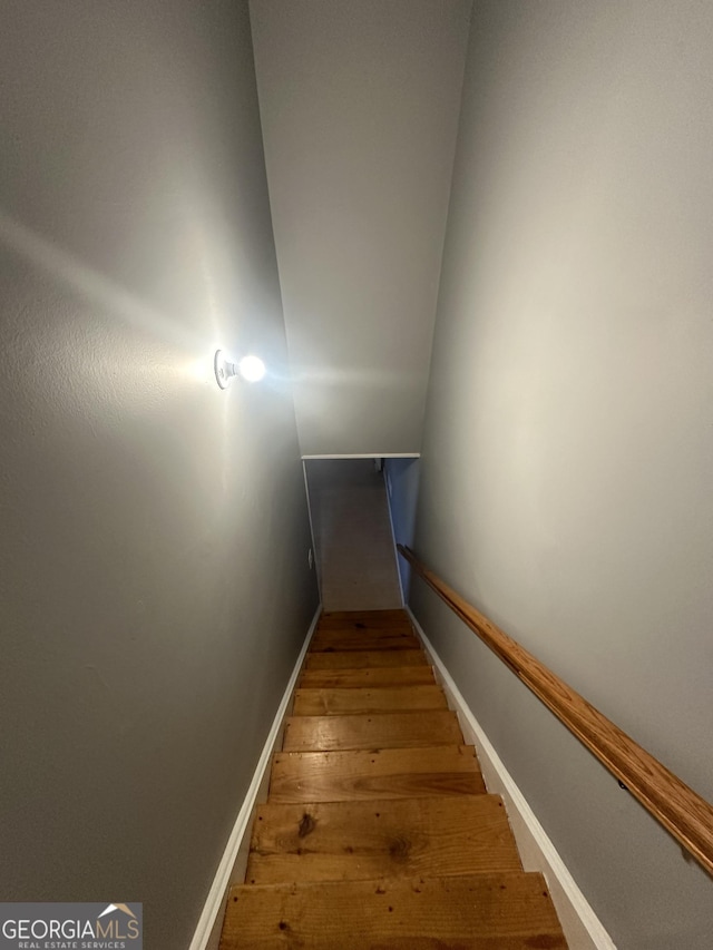 stairway with baseboards and wood-type flooring