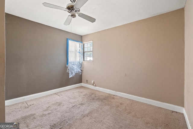 carpeted spare room with baseboards and ceiling fan