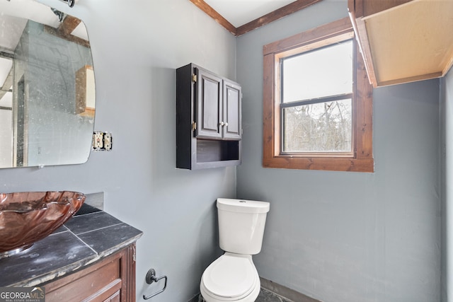 bathroom featuring toilet, vanity, and a shower