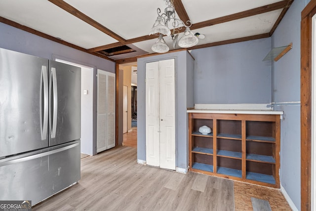 interior space with beam ceiling, coffered ceiling, wood finished floors, freestanding refrigerator, and baseboards