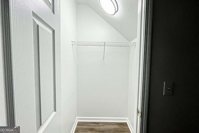 walk in closet featuring lofted ceiling and wood finished floors