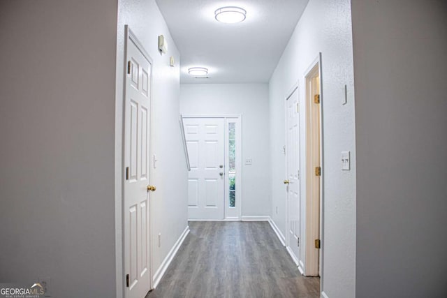 hallway with dark wood finished floors and baseboards