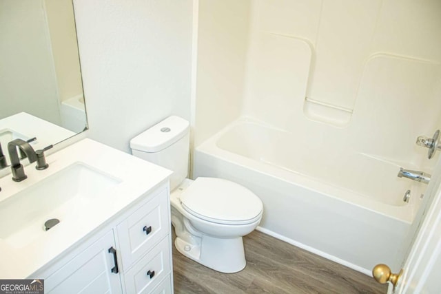 bathroom featuring vanity, toilet, wood finished floors, and tub / shower combination