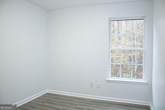 unfurnished room featuring dark wood-style floors and baseboards