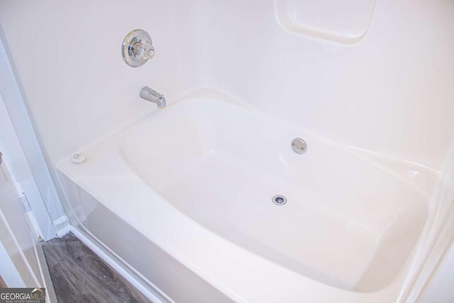 full bath with wood finished floors and a washtub