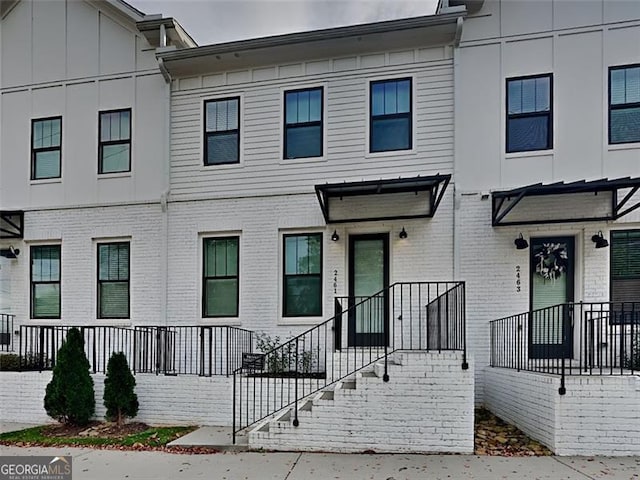 townhome / multi-family property featuring brick siding and board and batten siding