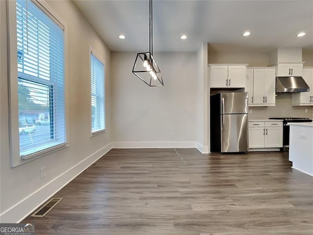 kitchen with visible vents, under cabinet range hood, stainless steel appliances, baseboards, and dark wood-style flooring