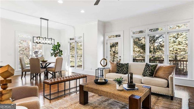 interior space featuring baseboards, a chandelier, ornamental molding, recessed lighting, and wood finished floors