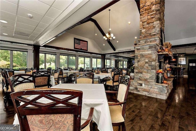 dining room featuring a chandelier, beam ceiling, wood finished floors, high vaulted ceiling, and ornate columns