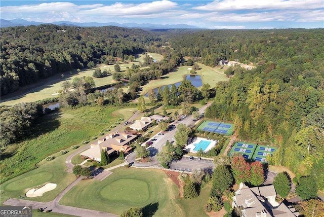 birds eye view of property featuring a forest view and a water view