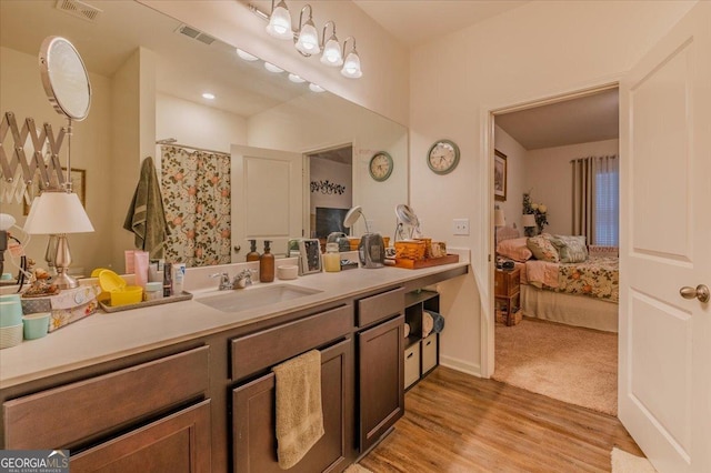 bathroom featuring visible vents, curtained shower, vanity, and wood finished floors