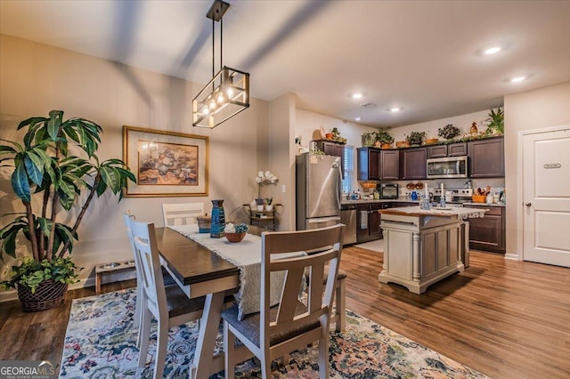 dining area featuring a notable chandelier, recessed lighting, baseboards, and wood finished floors