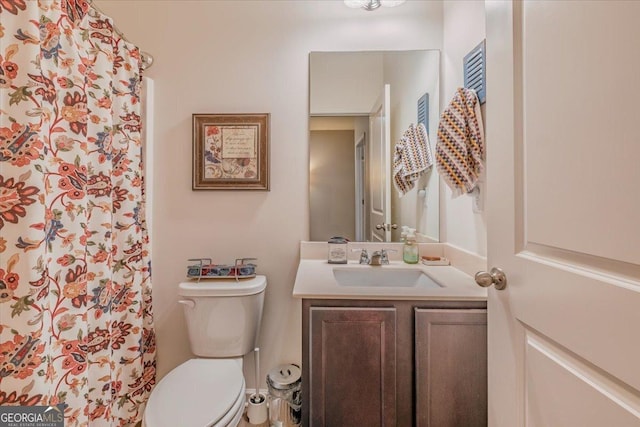 bathroom featuring vanity, curtained shower, and toilet