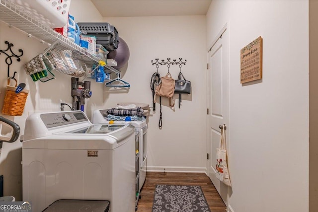 washroom featuring baseboards, dark wood-type flooring, separate washer and dryer, and laundry area