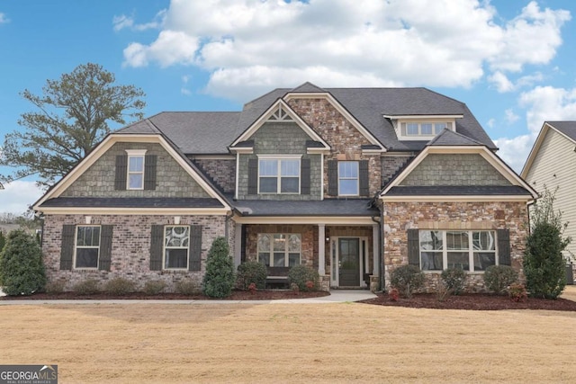 craftsman-style house with a shingled roof and a front yard