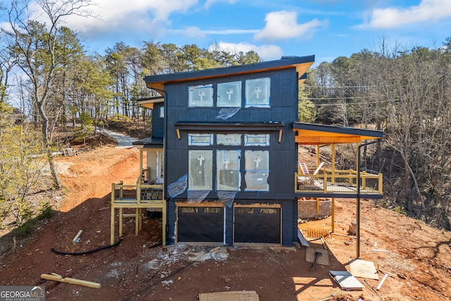 exterior space featuring a garage and dirt driveway