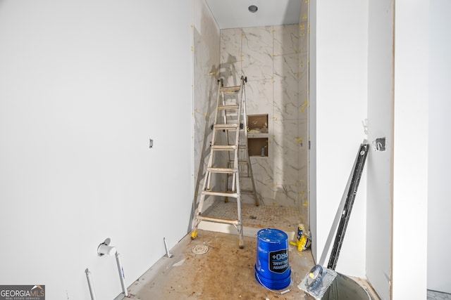 bathroom featuring a marble finish shower