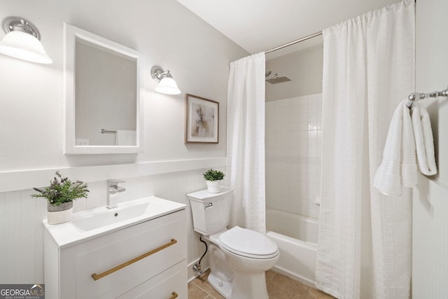 bathroom with vanity, wainscoting, tile patterned floors, toilet, and shower / tub combo with curtain