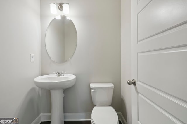 bathroom with toilet and baseboards