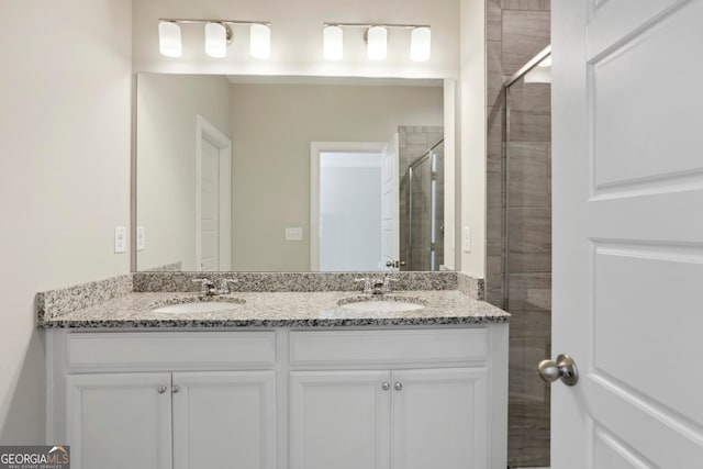 full bathroom featuring a sink, a shower stall, and double vanity