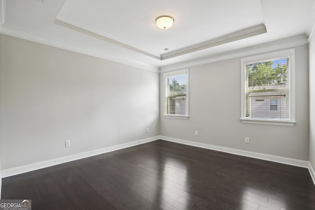 unfurnished room with a tray ceiling and dark wood-type flooring